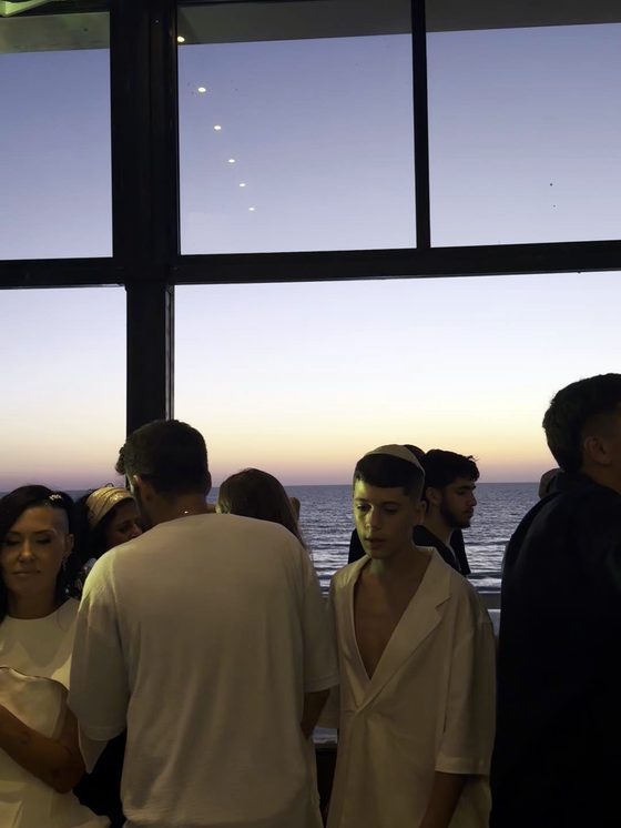 אורחים באירוע ערב על הרופטופ מול הים