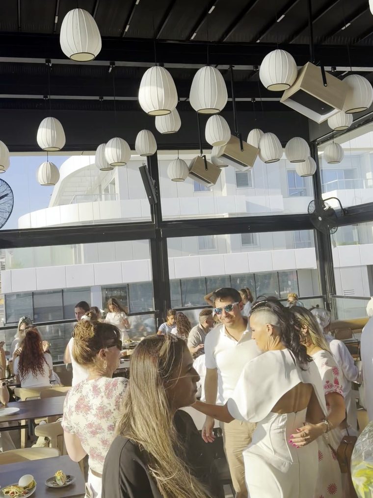 אורחים באירוע ברופטופ הפתוח של אומינו מתחת לפנסים